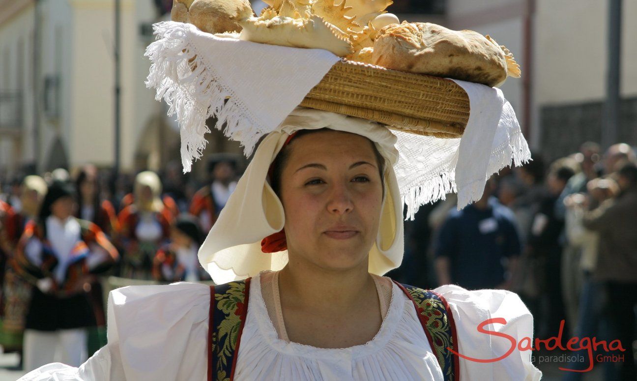 Woman in sardinian costume who is carrying a basket full of bread on her head