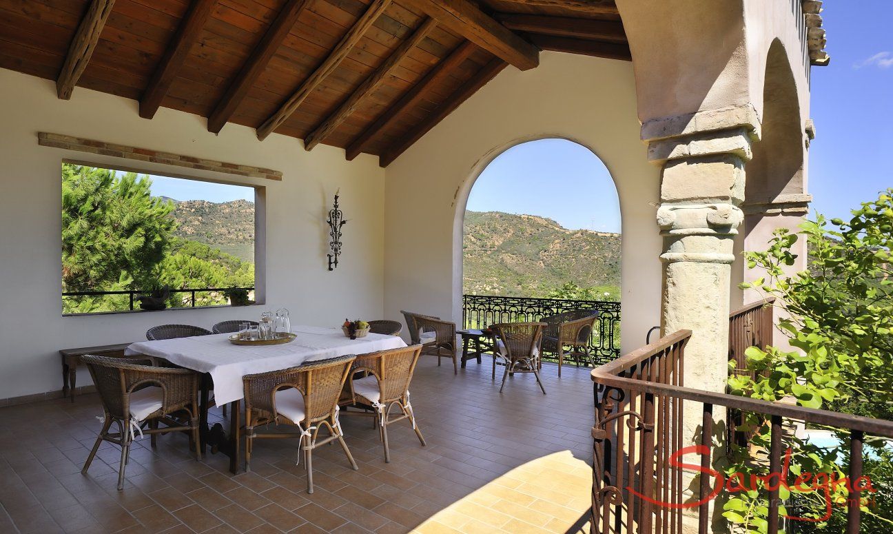 Roofed terrace with table for 8 people and view into the nature