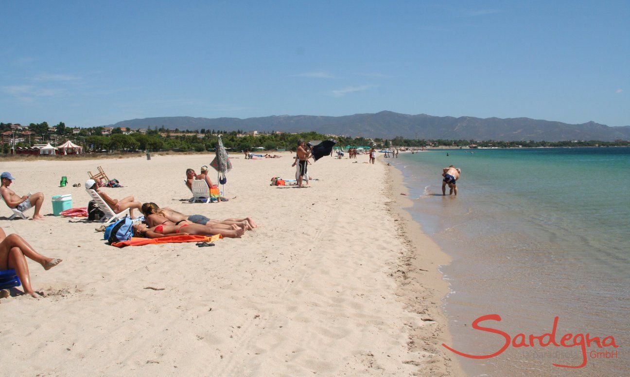 Taking a sunbath on the white sand of the beach Poetto close to Cagliari