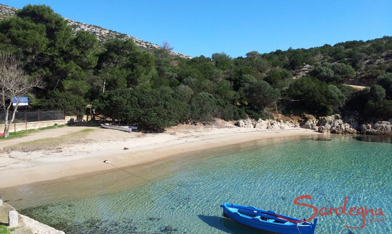 Traditional, blu fisherboat floats on the crystal clear water of the bay of Cala Moresca, Golfo Aranci
