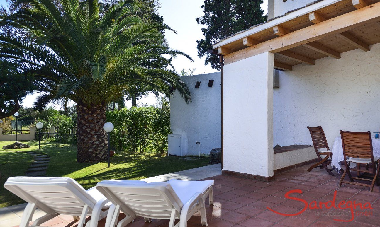 Villa Gaia | The comfortable sun loungers on the terrace offer a calming view into the green garden with palm trees terrace