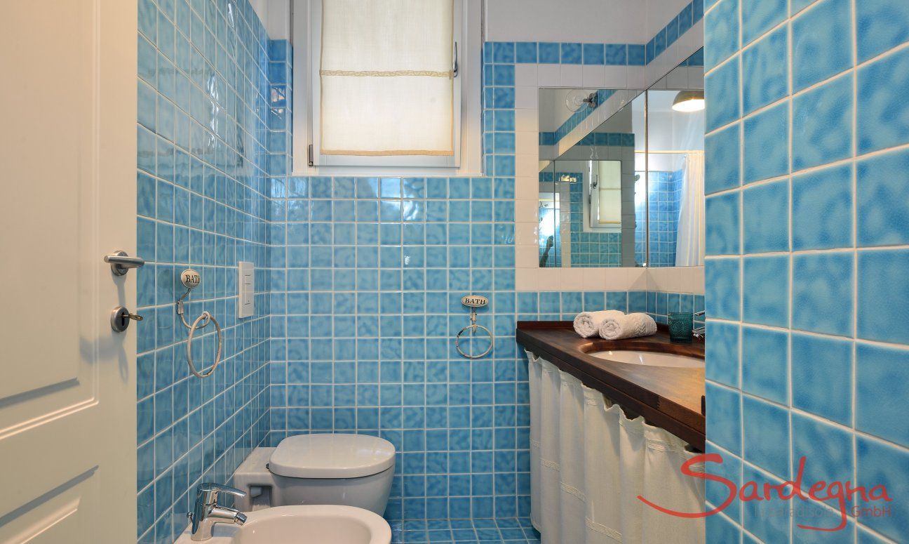 Li Conchi 9 | Ensuite bathroom of bedroom 1 Bath with light blue tiles and shower Li Conchi 9, Cala Sinzias