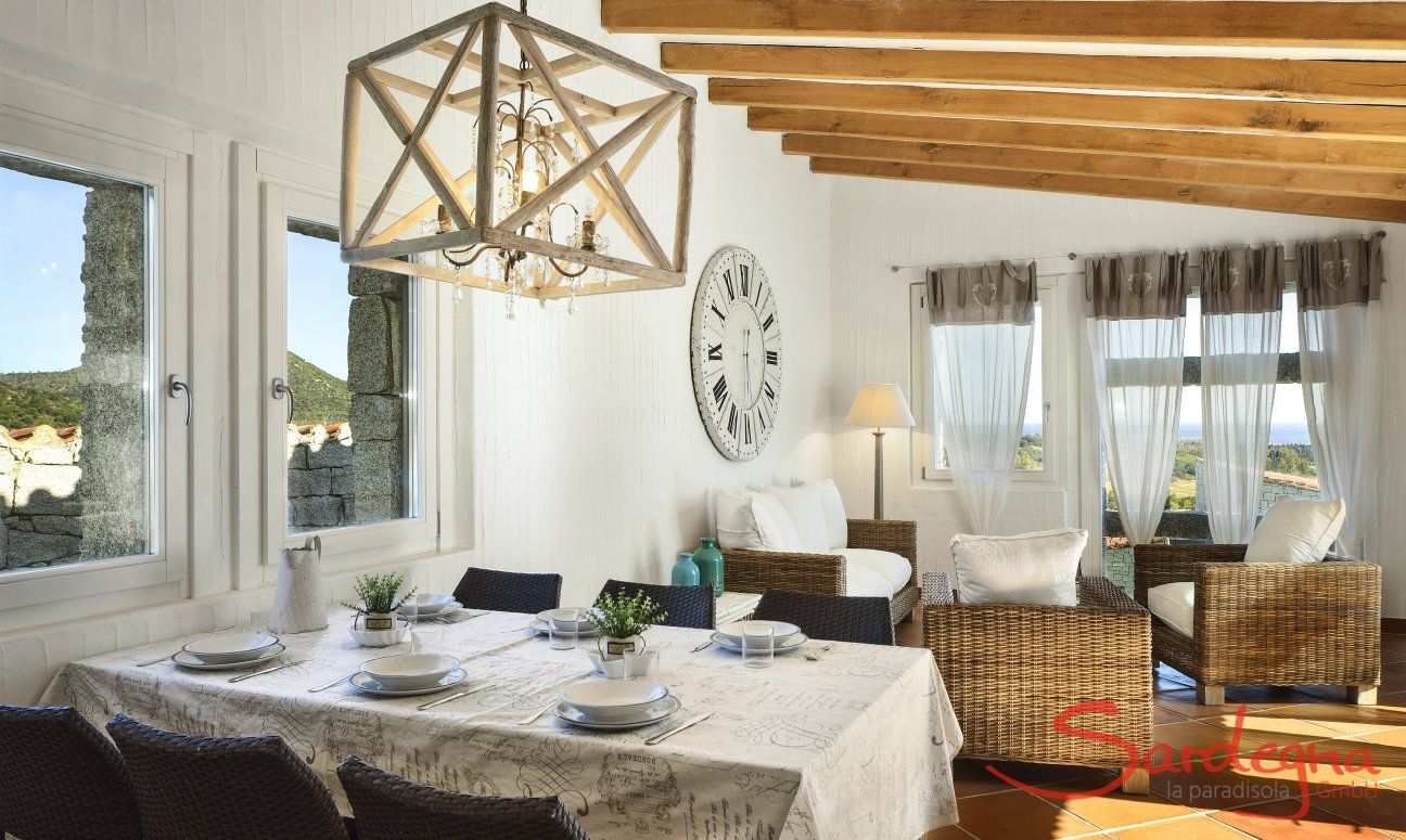 Li Conchi 10 | Living room with dining table, sofa corner and panoramic window Living Room Li Conchi 10, Cala Sinzias