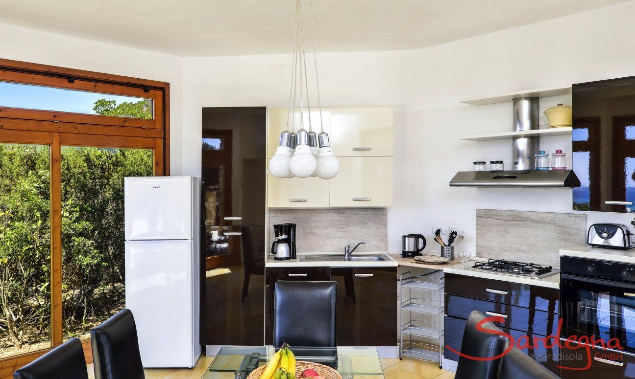 Villa Torretta Chia | Open kitchen and dining table Open kitchen and dining area inside