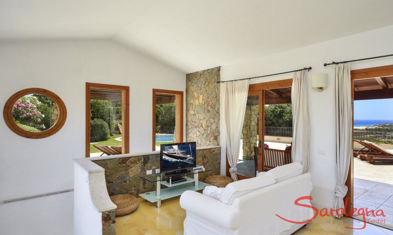 Villa Torretta Chia | Sofa corner with a tv and panorama windows Sofa corner with a tv and big windows
