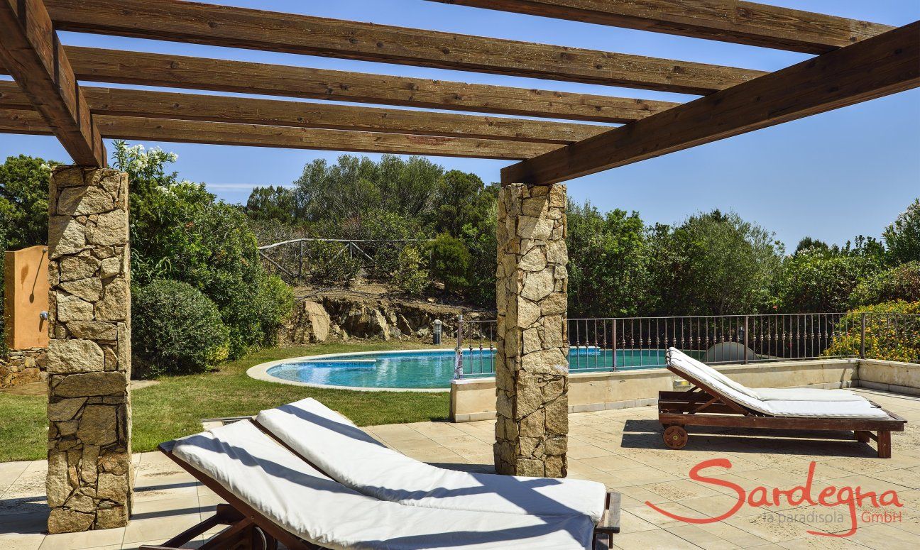 Villa Torretta Chia | Sunbeds on the terrace and the pool in the background Sunbeds on the terrace and the pool in the background