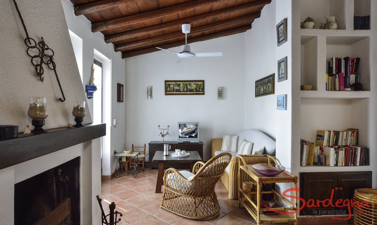 Villa Ibiscus | Living area with sofa corner, bookshelf and chimney Living area with sofa corner, bookshelf and chimney