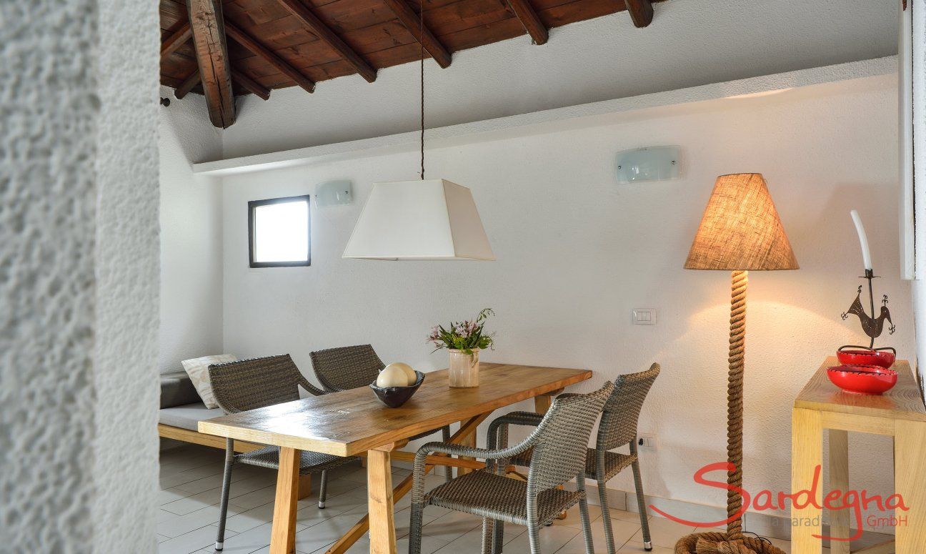 Villetta 3 | Wooden beam ceiling in the living area and cosy lighting at the dining table Dining area inside