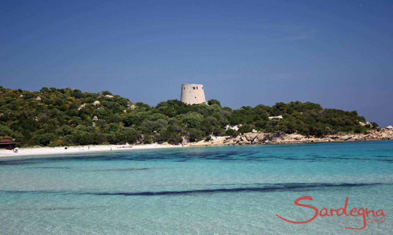 Crystal clear water, white sand and the old spanish tower in the bay of Cala Pira