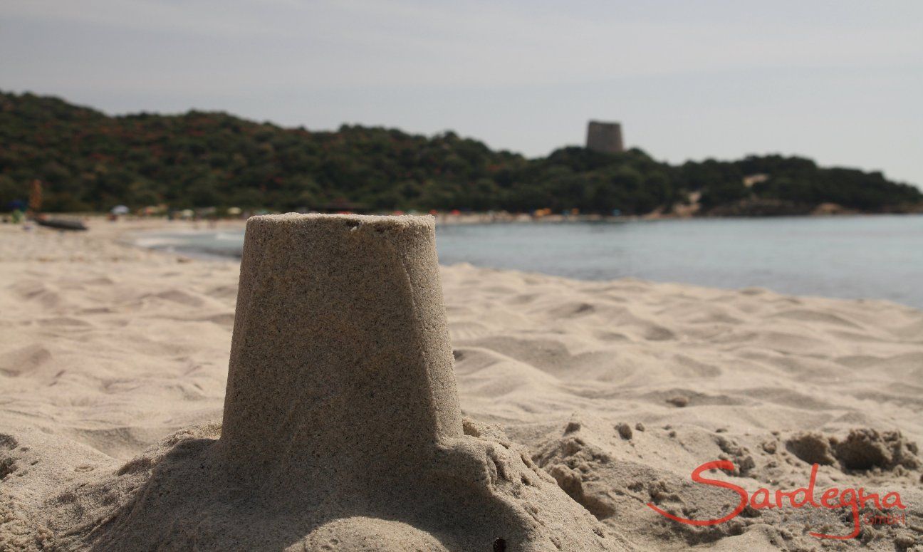 Close up of the sandmodel of the spanish tower of Cala Pira, in the background the real tower