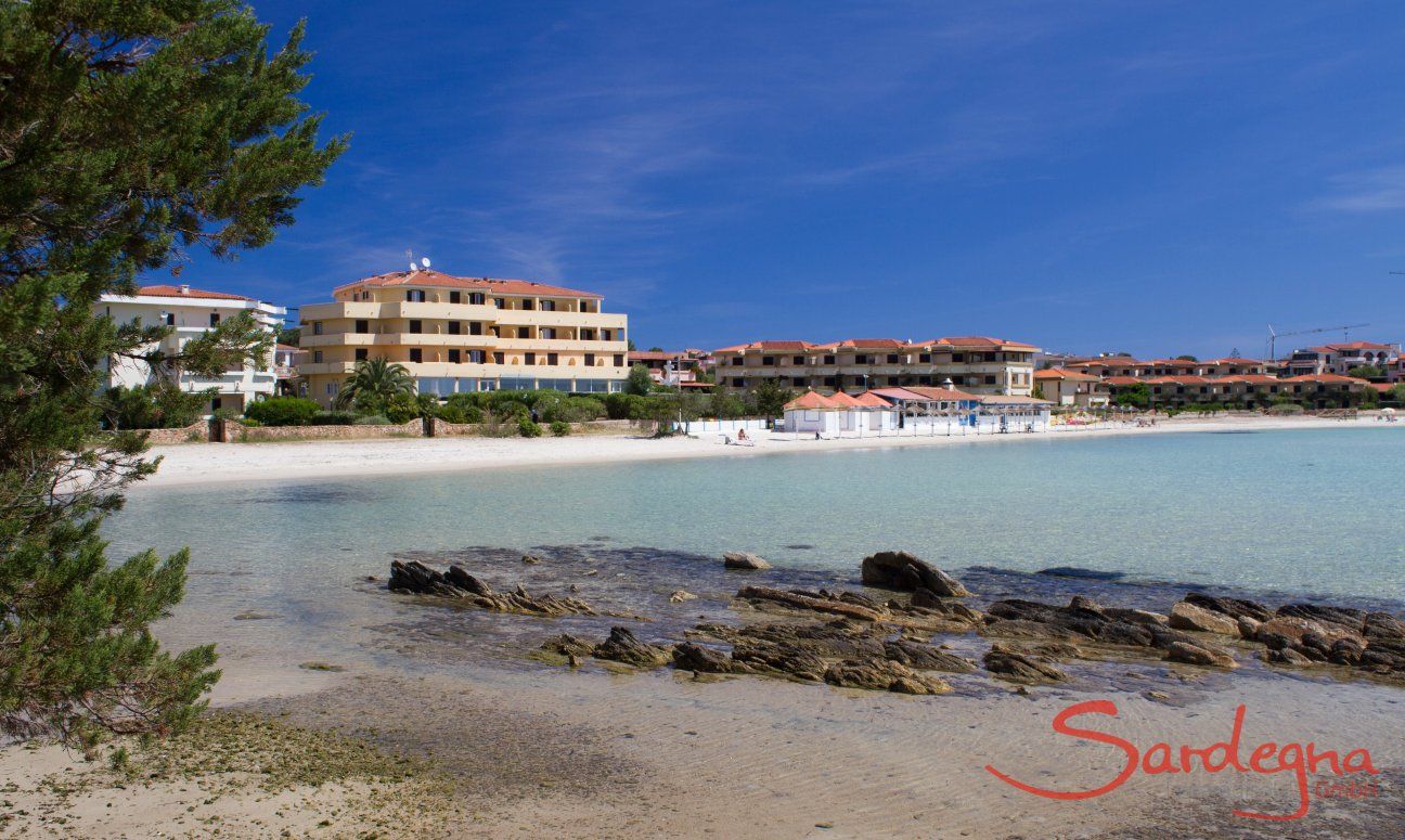 White beach and transparent sea just in front of the skyline of Golfo Aranci