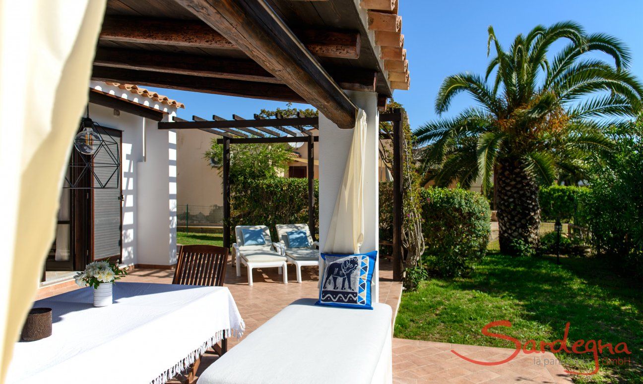 Terrace with dining area and sunbeds with garden view