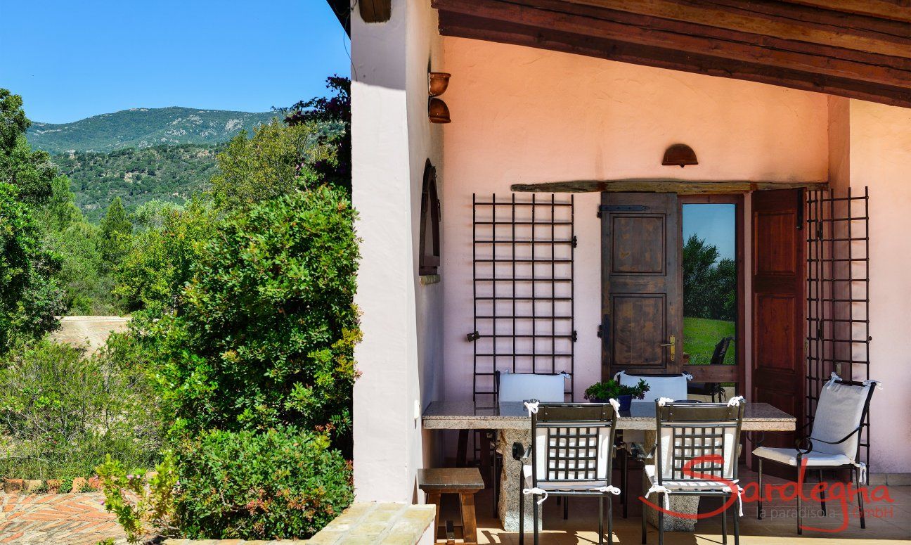 Roofed terrace with rustic granite table 