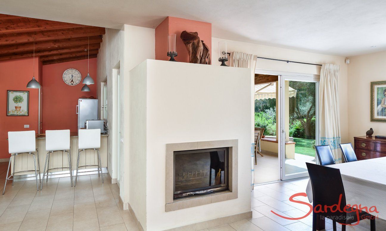 Villa Caroline | Chimney, terrace access, dining table and view towards the kitchen Chimney, terrace access, dining table and view towards the kitchen
