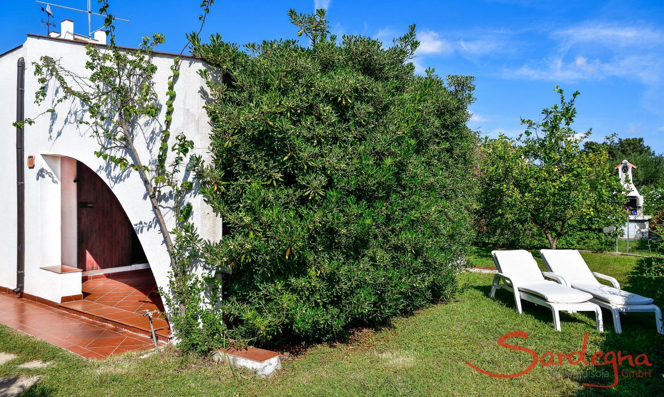 Villa Vela | Green garden with sun loungers House view of Villa Vela