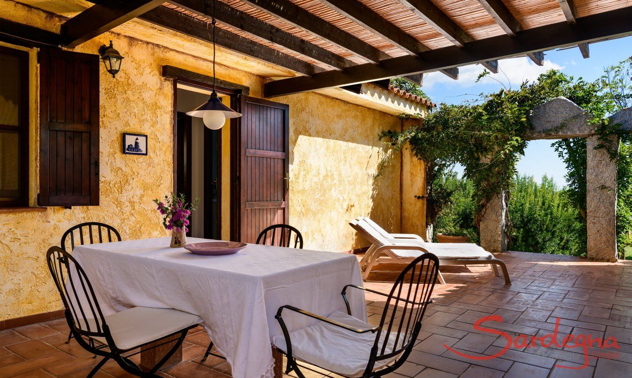 Casa Meloni 1 | Covered terrace with dining table and garden view Covered terrace with dining table