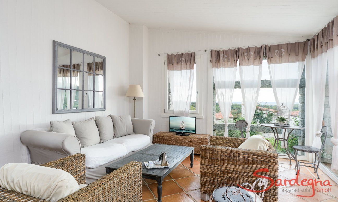 Living area with sofa, armchairs, TV and big panoramic window