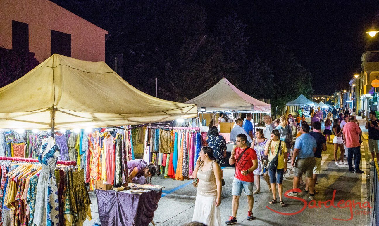 Stand selling colourful cloths on the streetmarket taking place on warm summernights in Golfo Aranci
