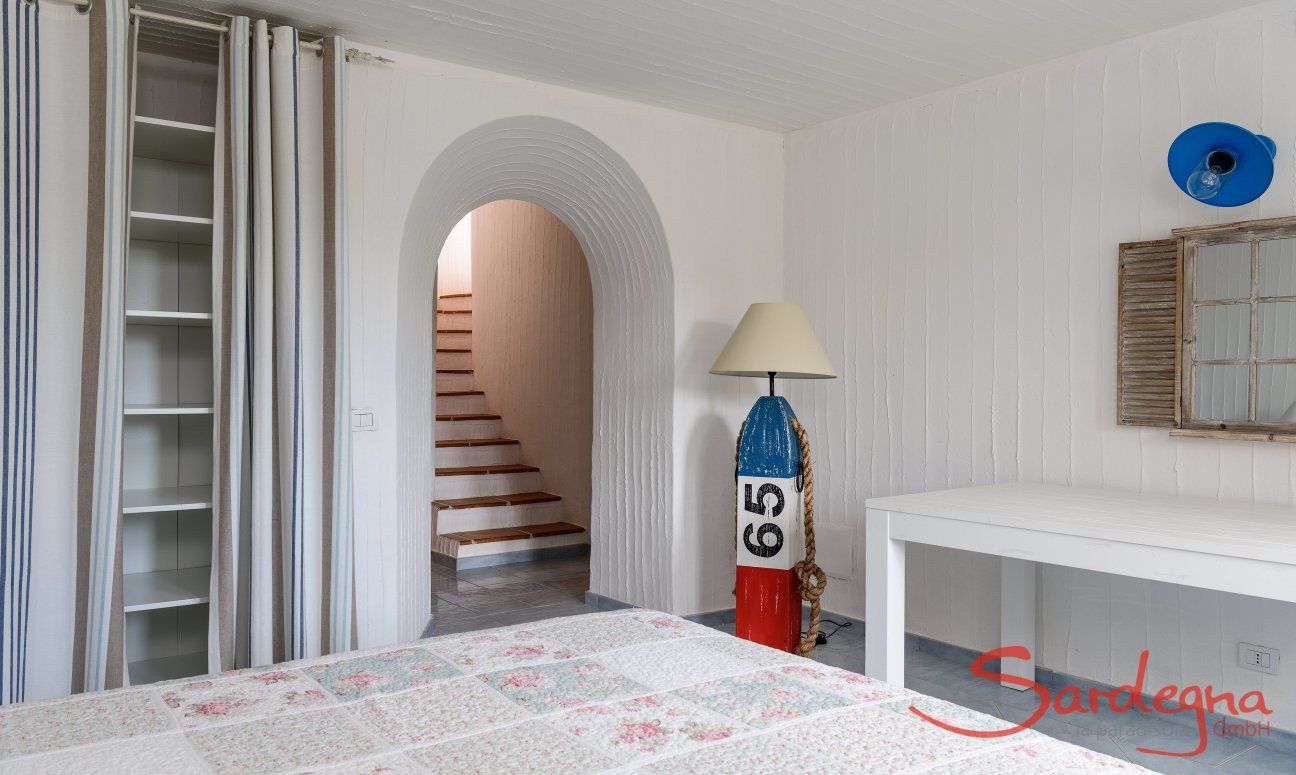 Li Conchi 30 | Stairs leading to bedroom 3 in the basement with double bed and wall closet Presentation of Li Conchi 30