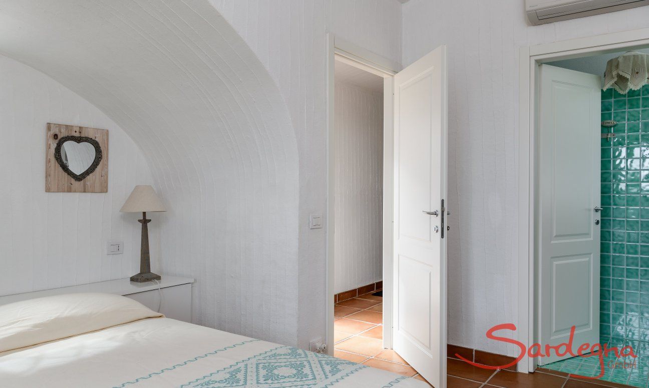 Li Conchi 30 | Bedroom 1 with the entrance door and door to the private bath Presentation of Li Conchi 30