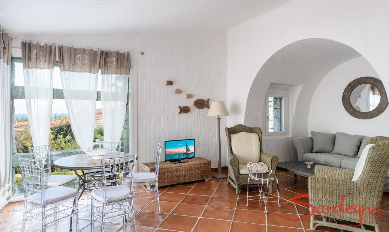 Li Conchi 30 | Relax area of the living room with round table in front of the panomrama window, TV and sofa corner Presentation of Li Conchi 30