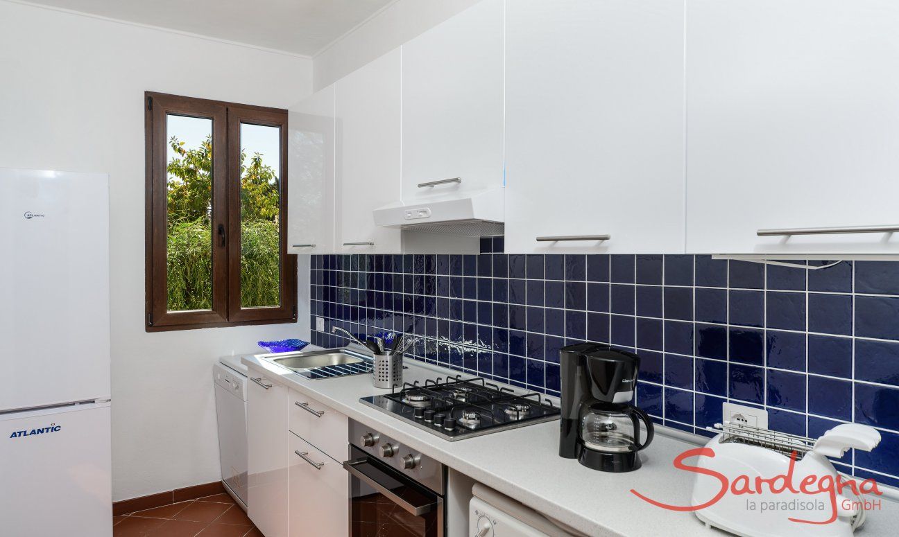 Casa Su Faru 2 | White and blue modern kitchen with oven, gas stove, dishwasher, washing machine and big fride/freezer White and blue modern kitchen in Su Faru 2 Pula
