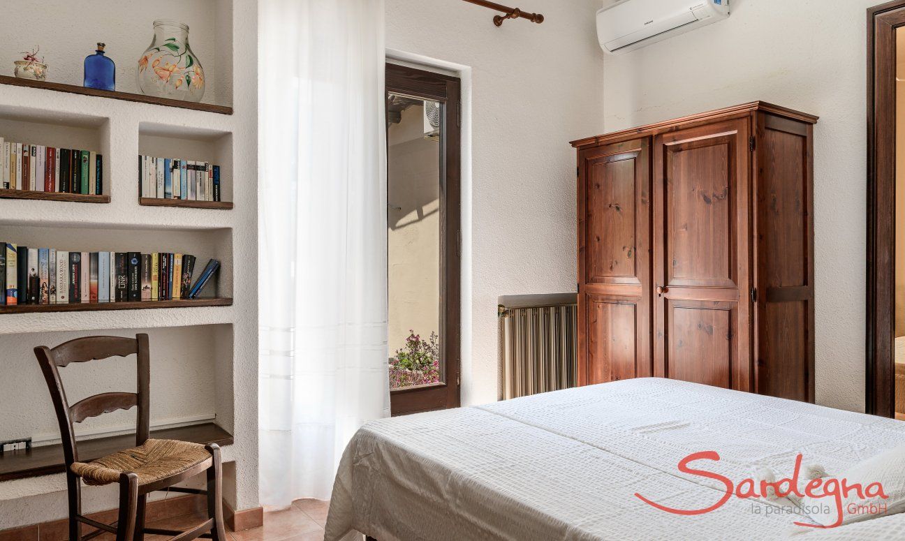 Villa Palme | Bedroom 1 with library and airconditioning Villa Palme, Costa Rei