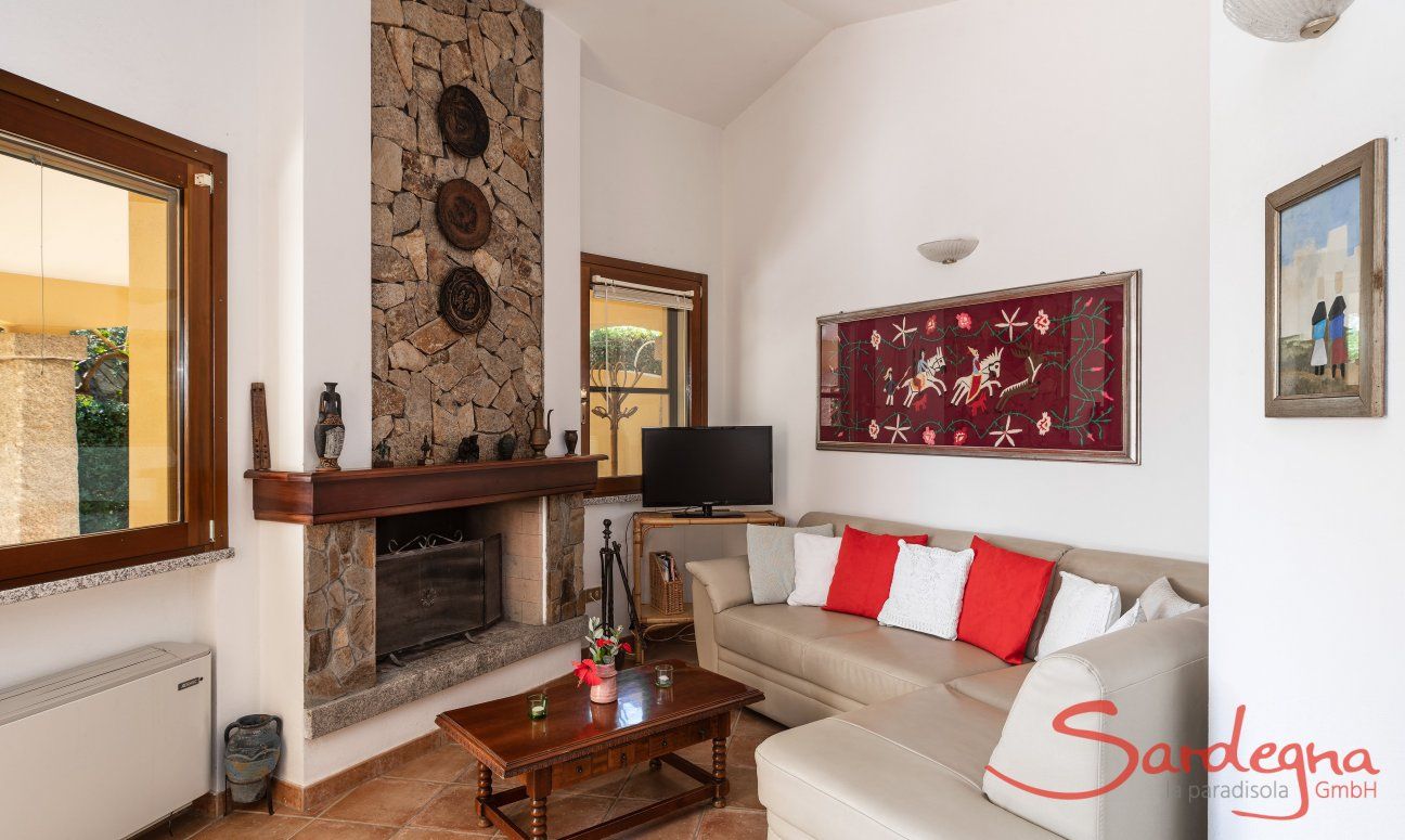 Villa Tiziana 11 | Comfortable sofa corner with TV and fireplace for the colder and air conditioning for the warm days Portrait of the house