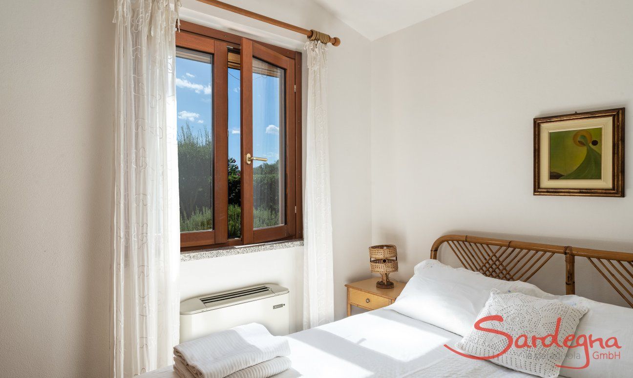 Villa Tiziana 11 | Bedroom 1 with double bed and view into the green nature Portrait of the house