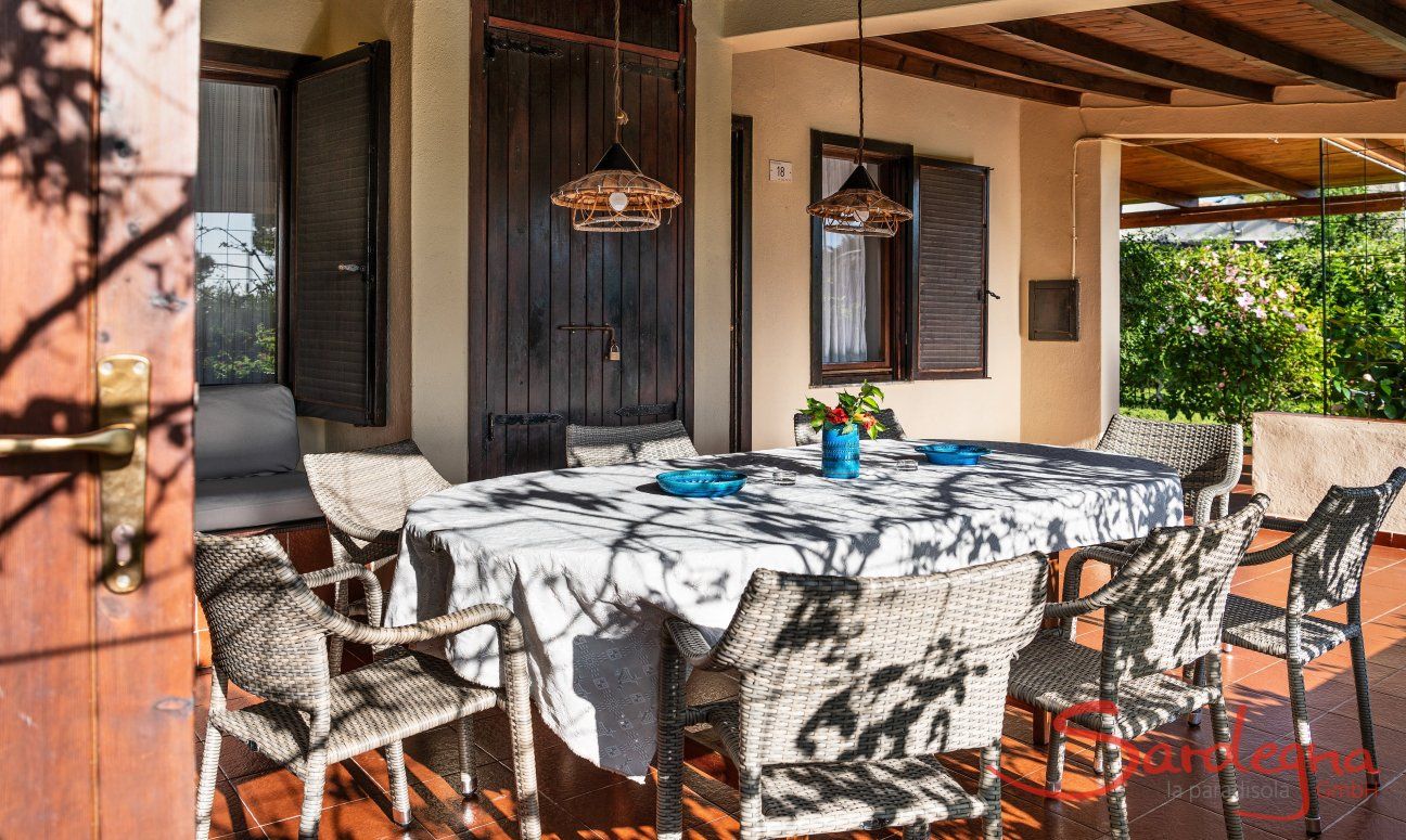 Villa Romana | Big, oval dining table for eight people on the roofed terrace Outdoor area with garden and terrace