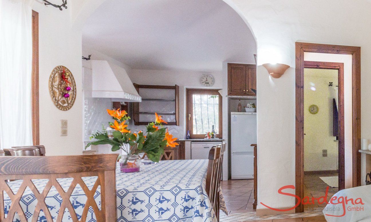 Villa Maestrale | Dining table, kitchen and door to the bed room Villa Maestrale, Cala Ginepro, Olbia