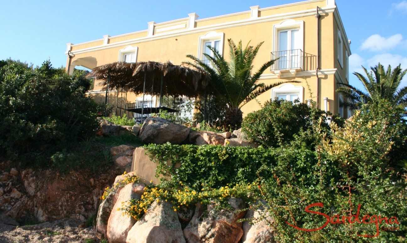 Villa Aquila Alta | Villa Aquila surrounded by rocks, palm trees and bushes Sardinia