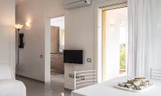 Villa Caterina | Entrance area with TV and airconditioning View to kitchen