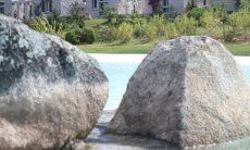 Pool of Li Conchi with big granite blocks and the houses in the back