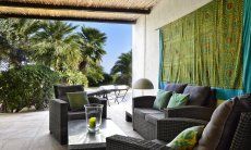 Roofed lounge area with a view towards the garden 