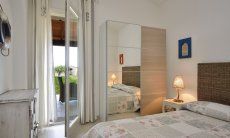 Bedroom with double bed, cupboard and door to the terrace  Villa Campidano 21