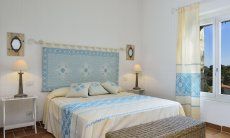 Li Conchi 7 | Bedroom 1 with double sized bed and sardinian decoration Bedroom with double bed and window with garden view, Li Conchi 7