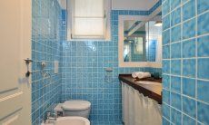 Li Conchi 9 | Ensuite bathroom of bedroom 1 Bath with light blue tiles and shower Li Conchi 9, Cala Sinzias