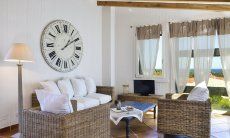 Li Conchi 9 | Sofa corner with sea view Sofa corner with big clock and panoramic window Li Conchi 9, Cala Sinzias