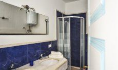 Villa Torretta Chia | Bathroom 3 with shower and two sinks and washing machine Bathroom 2 with shower and two sinks