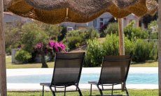 Sunbeds underneath an ombrella by the pool of Li Conchi