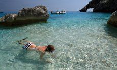 Young girl snorkelling in the transparent water of Cala Goloritze