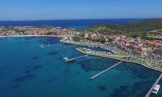 Airview of Golfo Aranci with boadwalk along the harbour an white beach