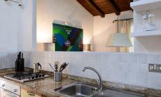 Villa Kika | Kitchencounter with sink, gasstove and oven and open window to the dining area Kitchencounter with sink, gasstove and oven and open window to the dining area