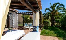 Terrace with dining area and sunbeds with garden view