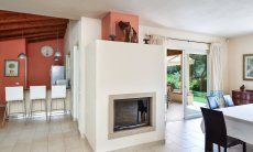 Villa Caroline | Chimney, terrace access, dining table and view towards the kitchen Chimney, terrace access, dining table and view towards the kitchen