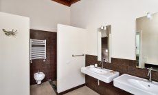 Villa Caroline | Modern bathroom 1 with two sinks and a walk-in shower Modern bathroom 1 with two sinks and a walk-in shower
