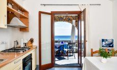 Apartment Castededdu 5 | Kitchen with terrace access and sea view Kitchen with terrace access and sea view