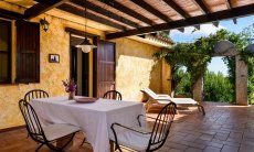 Casa Meloni 1 | Covered terrace with dining table and garden view Covered terrace with dining table