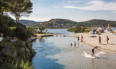 Kids play in the shallow water of the lagoon of Porto Taverna